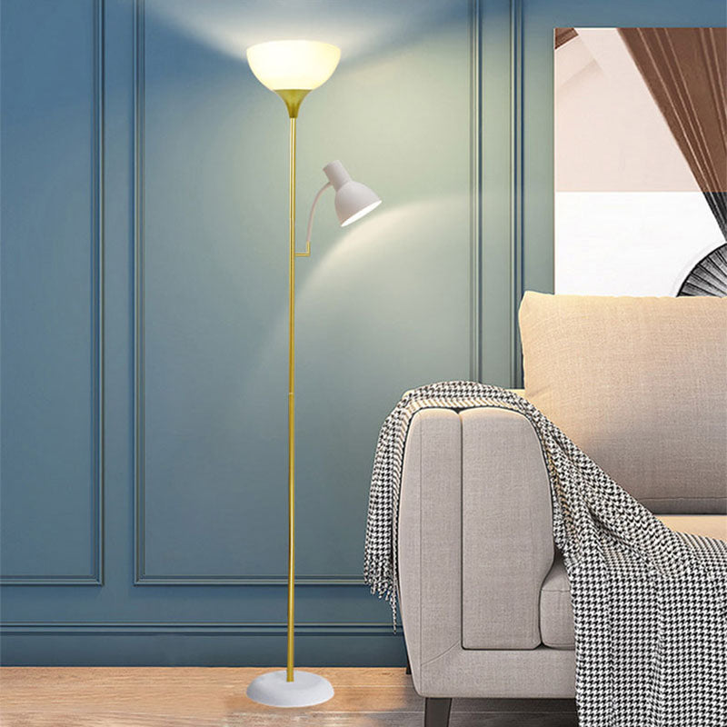 Stehlampe mit weißem Schirm und Leselicht neben blauem Sessel und rundem Beistelltisch