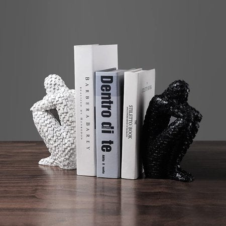 Skulpturale Buchstütze aus Kunstharz neben aufrecht stehenden Büchern