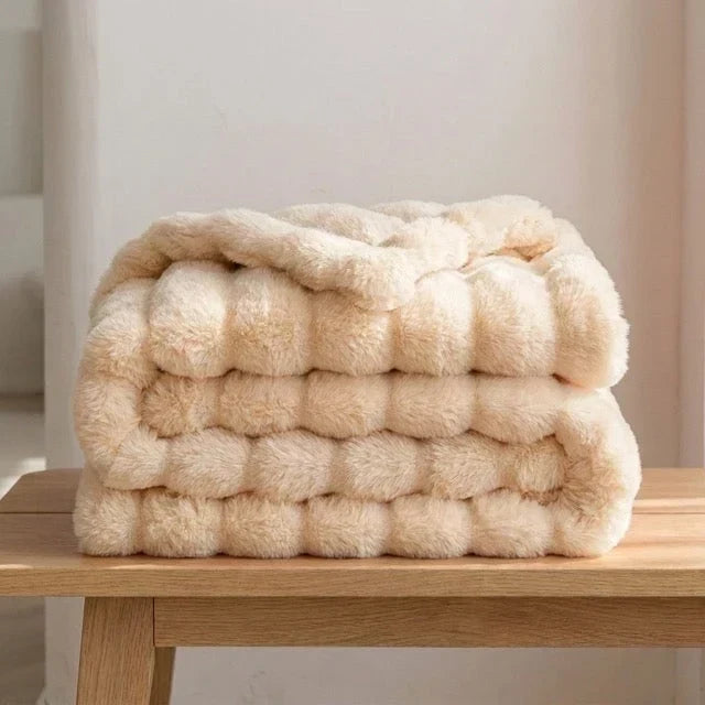 Kunstfelldecke vollständig ausgebreitet auf einem Bett