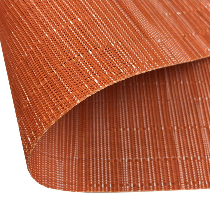 Detailansicht eines orangefarbenen Platzsets mit dekorativem Herbstarrangement