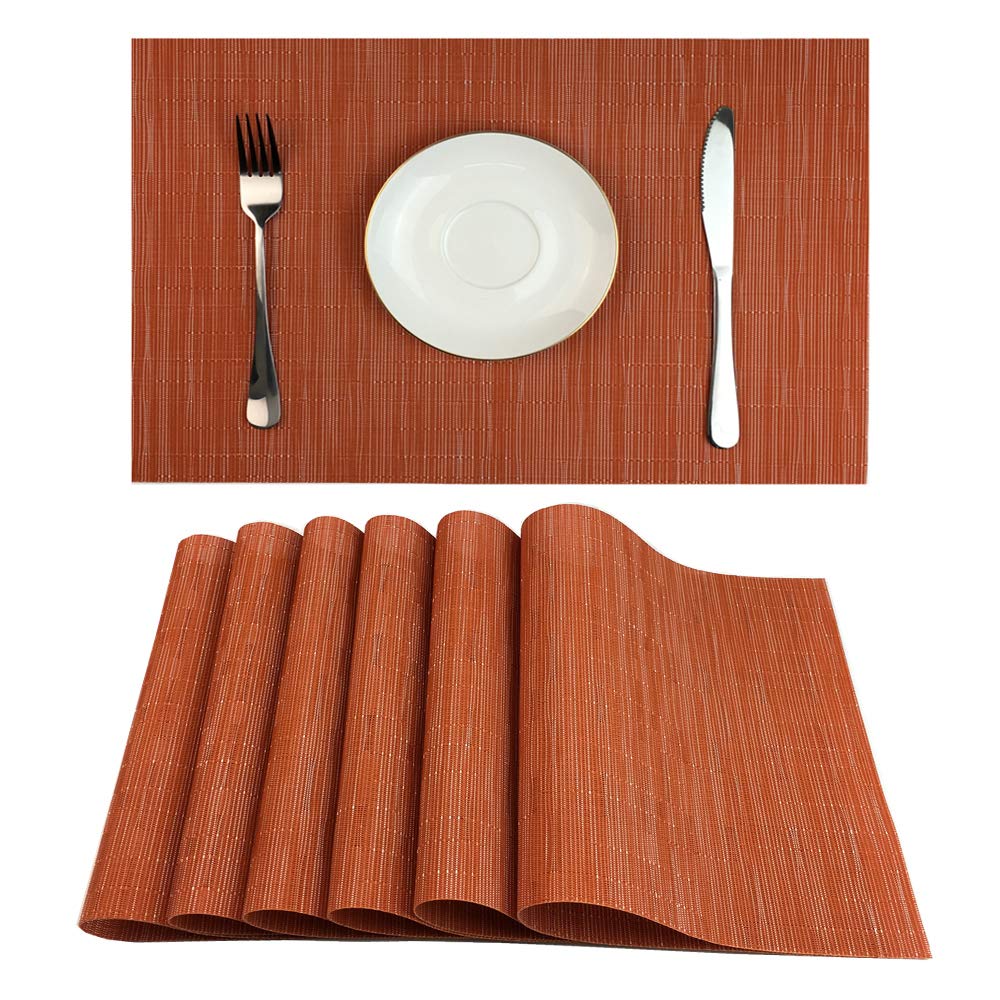 Sechs orange Platzsets für eine herbstliche Tischdekoration auf einem gedeckten Tisch