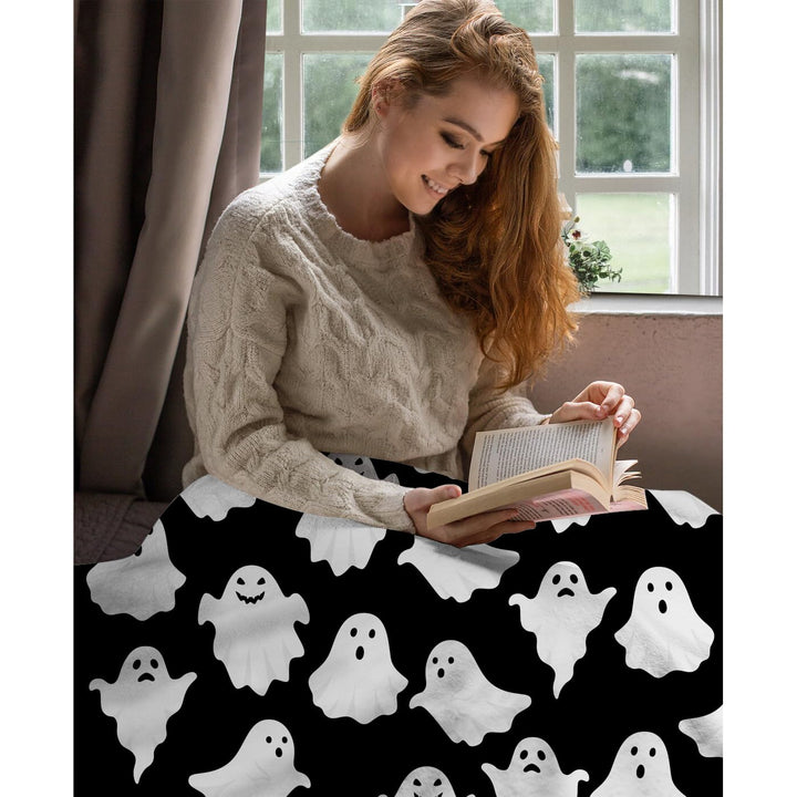 Halloween-Decke mit Geistermotiv auf einem gemütlich dekorierten Bett