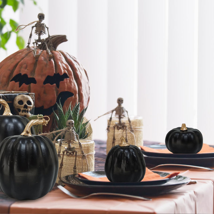 Künstliche schwarze Kürbisse als Halloweendekoration auf einem Tisch