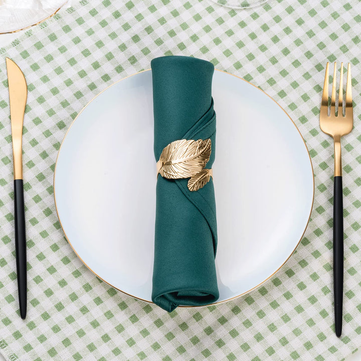 Goldene Serviettenringe mit weißen Stoffservietten auf elegantem Gedeck