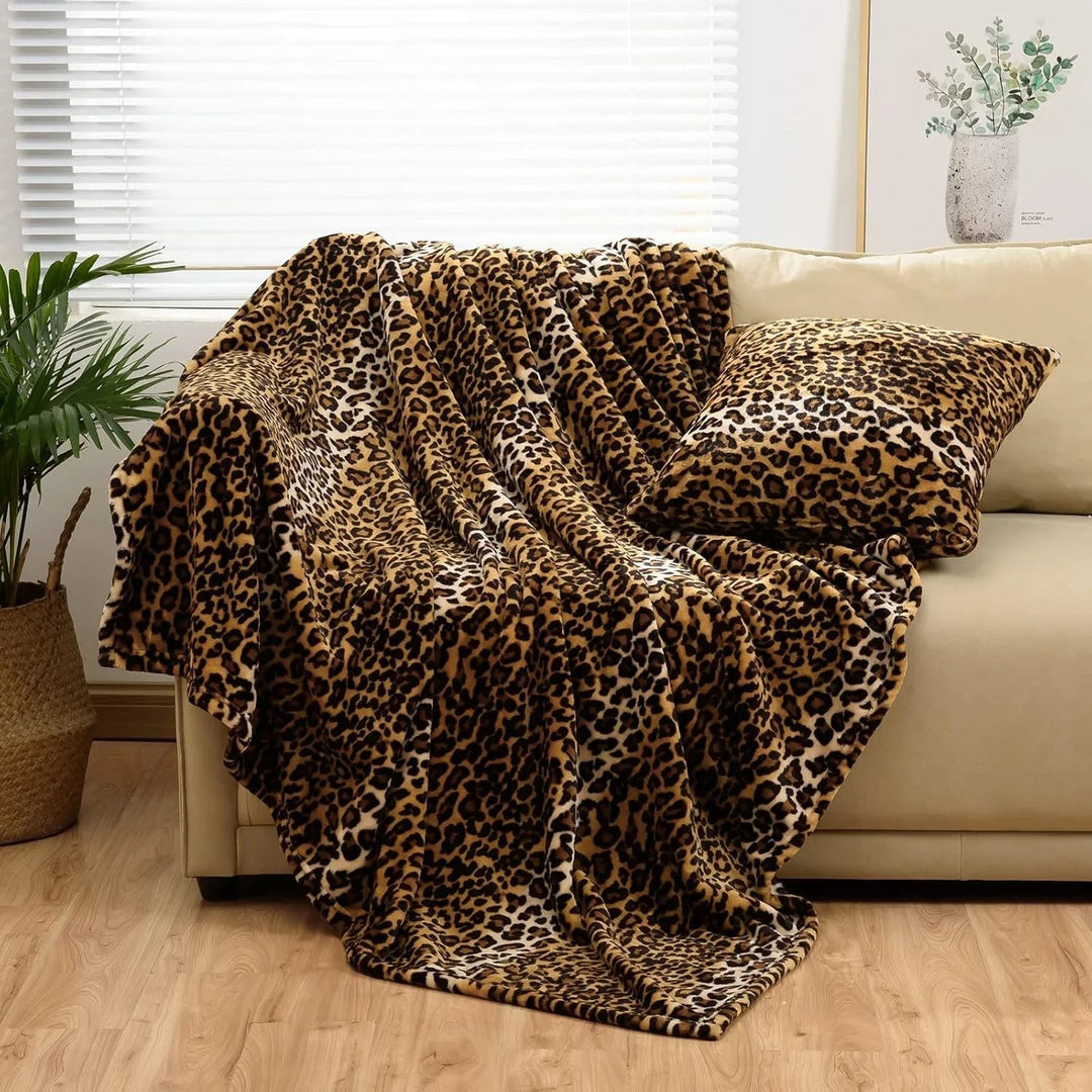 Kuscheldecke aus Flanell mit Leopardenmuster dekorativ auf einem Sofa drapiert