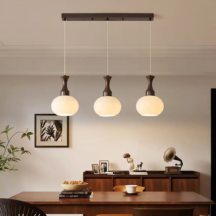 Pendelleuchte Holz Glas modern über einem Esstisch inszeniert