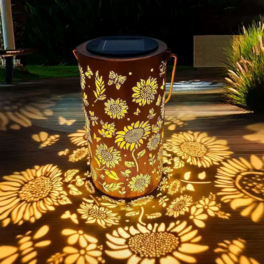 Solar Gartenlaterne aus Metall mit Blütenmuster und Lichtprojektion im Garten