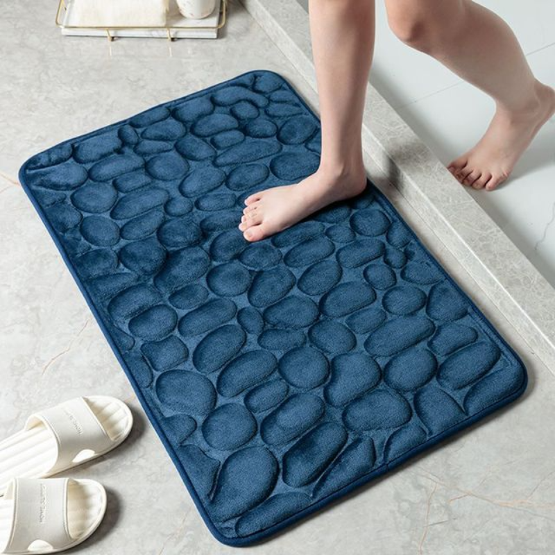 Memory-Foam-Badematte im Kieselstein-Design vor einer Badewanne