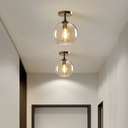 Moderne Deckenleuchte mit klarem Glasschirm und Messingdetails