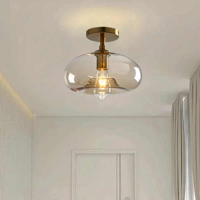 Moderne Deckenleuchte mit klarem Glasschirm und Messingdetails