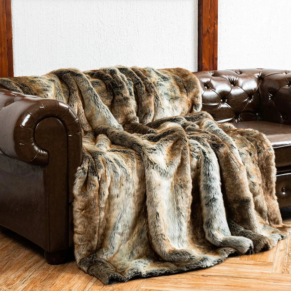Warme Kunstfell-Kuscheldecke dekorativ über einem Sofa drapiert
