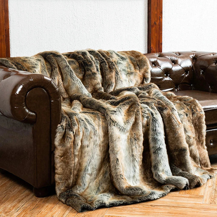 Warme Kunstfell-Kuscheldecke dekorativ über einem Sofa drapiert