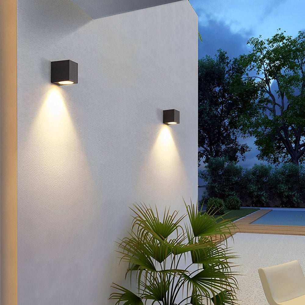 Moderne Außenwandleuchte in quadratischer Form mit Lichtkegel an der Fassade